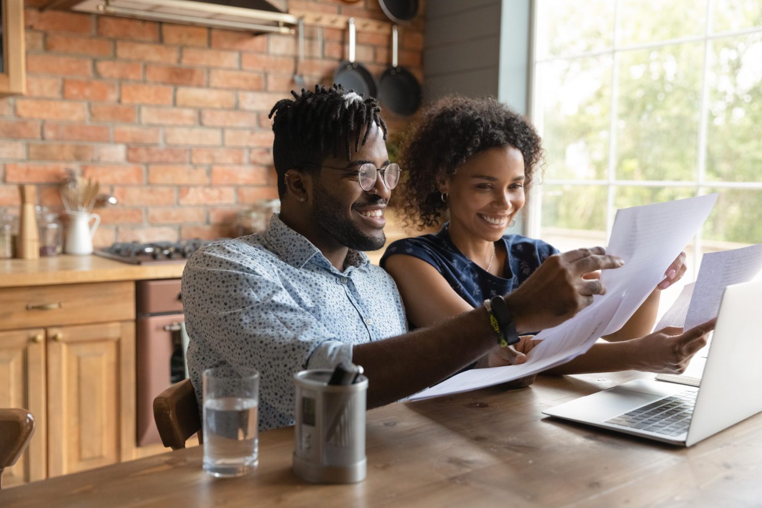 Happy 30s african ethnicity biracial family couple involved in paperwork. Happy 30s african ethnicity biracial family couple involved in paperwork.