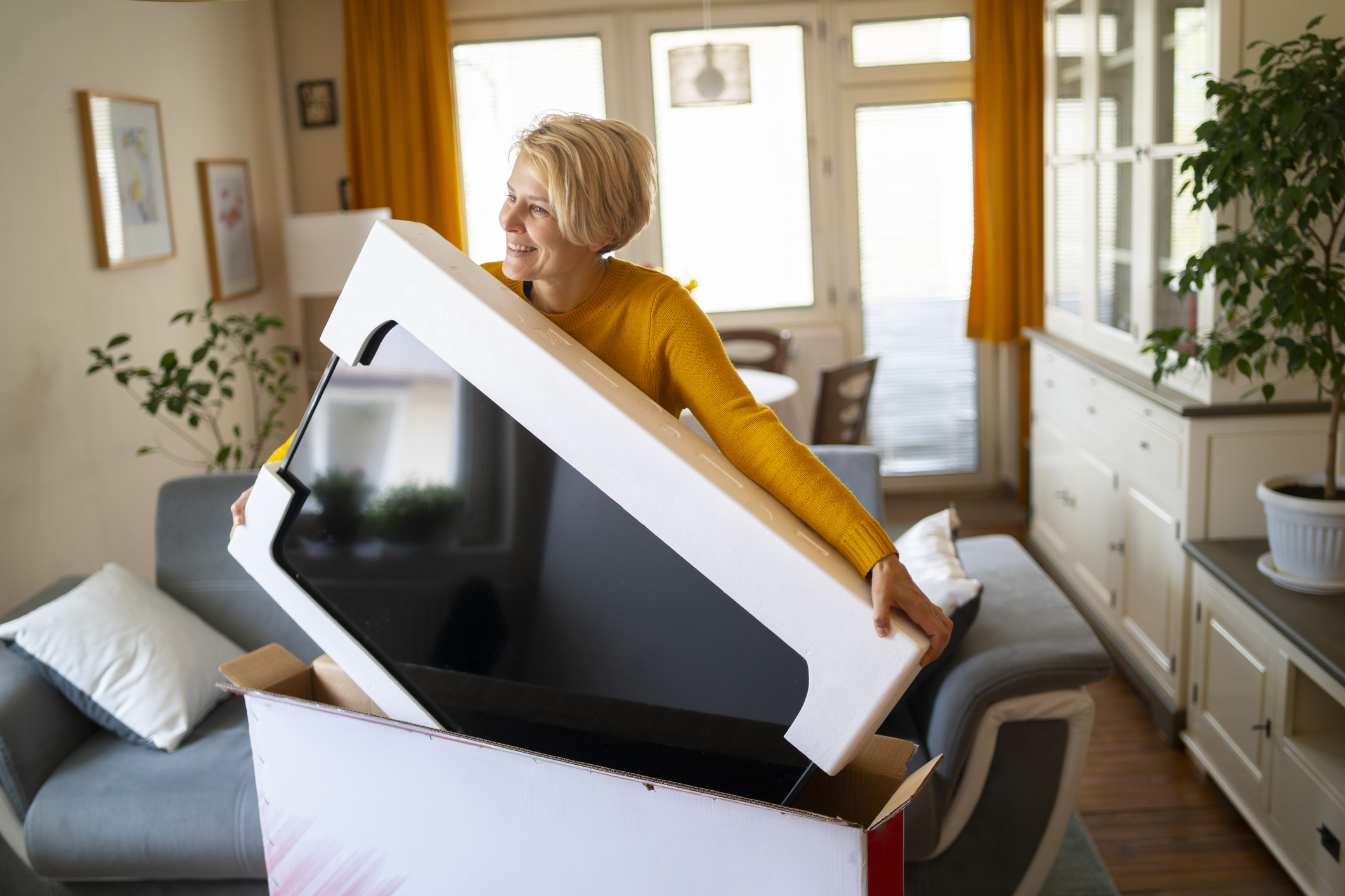 An online shopper lifts her new purchase from its box An online shopper lifts her new purchase from its box